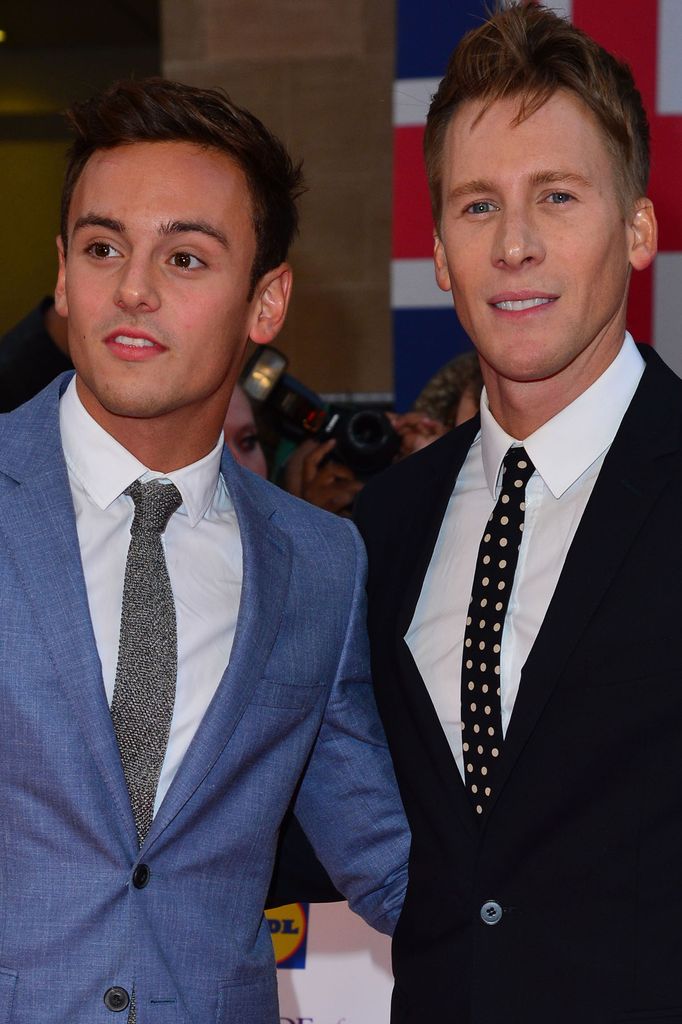 Tom Daley in a blue suit and Dustin Lance Black in a black suit