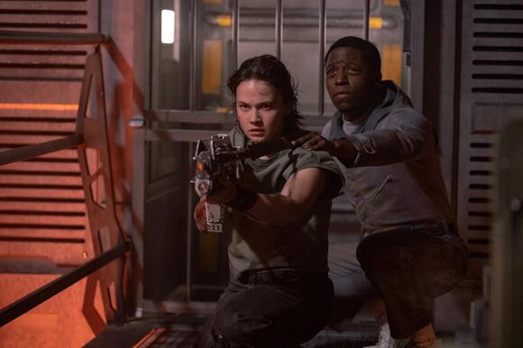 Rain Carradine (Cailee Spaeny) and android Andy (David Jonsson) take aim at extraterrestrial foes in 'Alien: Romulus.' MURRAY CLOSE/20TH CENTURY STUDIOS