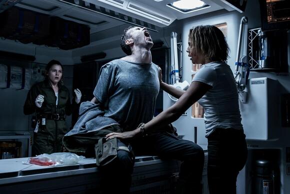 Ledward (Benjamin Rigby, center) has something growing in him and crewmates Faris (Amy Seimetz) and Karine (Carmen Ejogo) can't do much to help in 'Alien: Covenant.' MARK ROGERS/20TH CENTURY STUDIOS