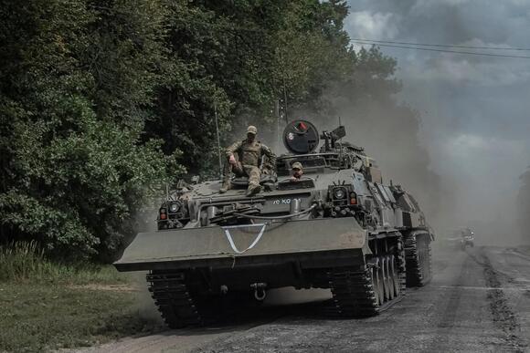 Ukrainian servicemen ride a military vehicle near the Russian border in Ukraine's Sumy region on August 10.