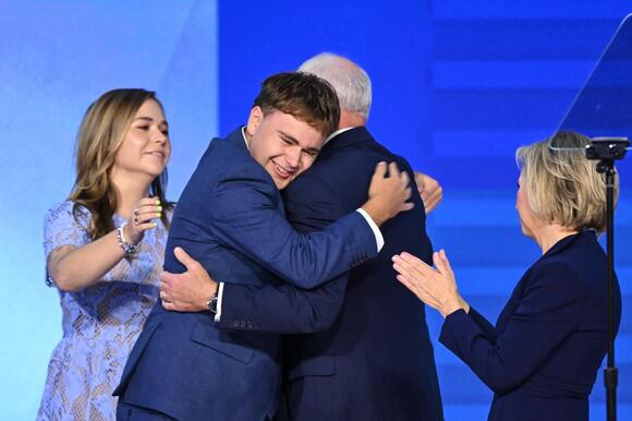 Gus hugs his father on stage at the DNC