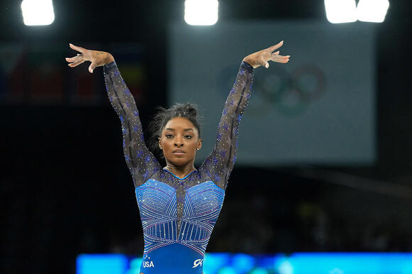 Simone Biles competing on the beam during the Paris 2024 Olympic Summer Games at Bercy Arena.