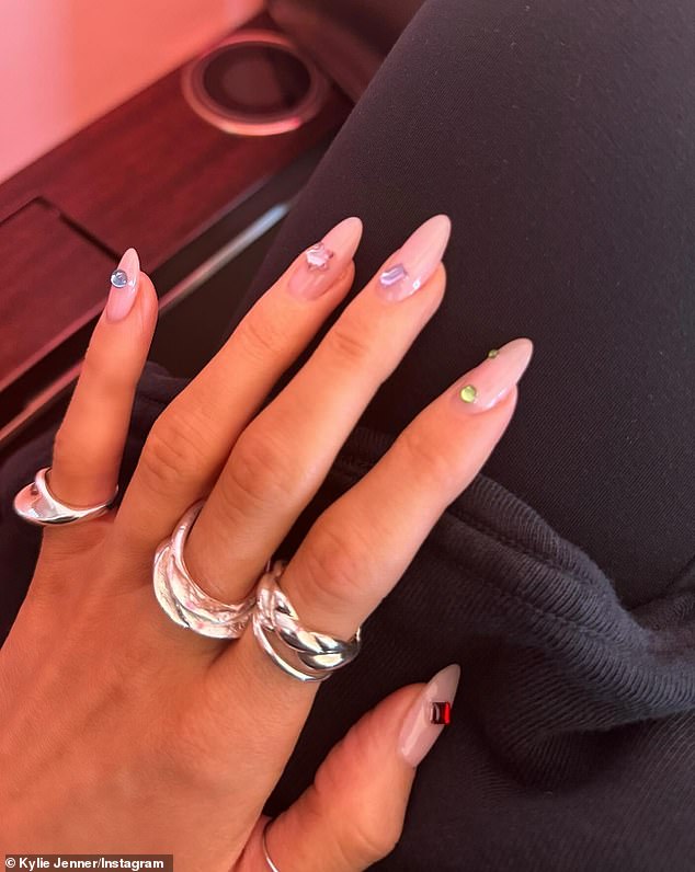 The reality icon gave her fans a closeup of her impeccable pale pink nails — which were of a more modest length than she usually wears. She had multicolored stones glued to the nails, and she sported multiple silver rings