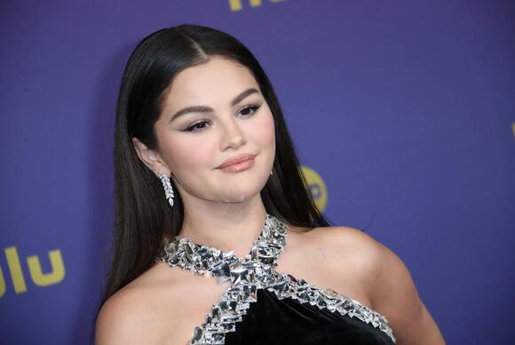 Selena Gomez walks the red carpet at the 76th Emmy Awards.